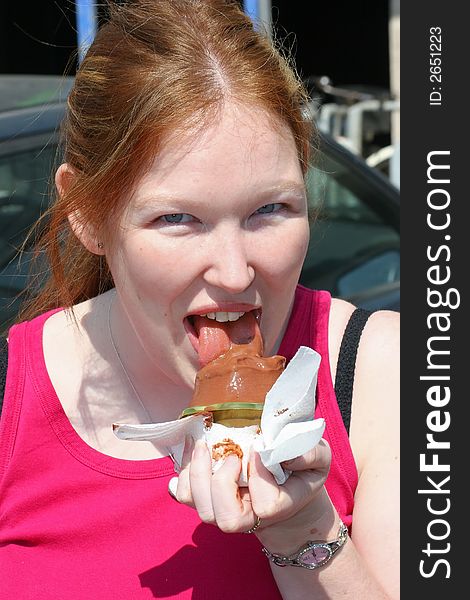 A girl makes a mess of eating a chocolate ice cream. A girl makes a mess of eating a chocolate ice cream