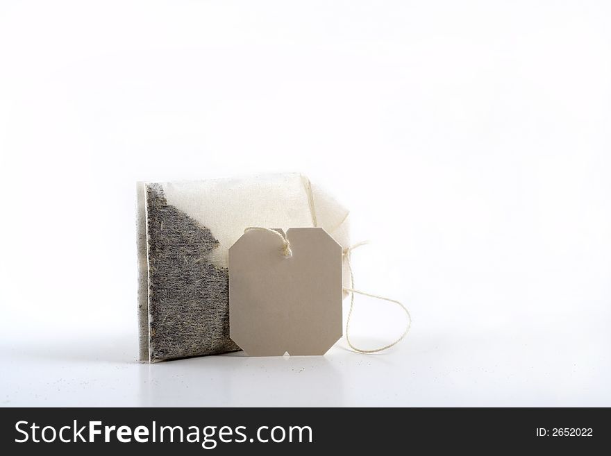 Tea bag on its side with blank label attached. Tea bag on its side with blank label attached