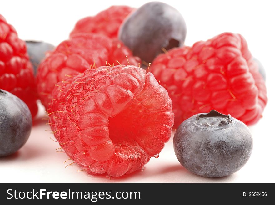 Ripe raspberries and blueberries on a white background. Ripe raspberries and blueberries on a white background.