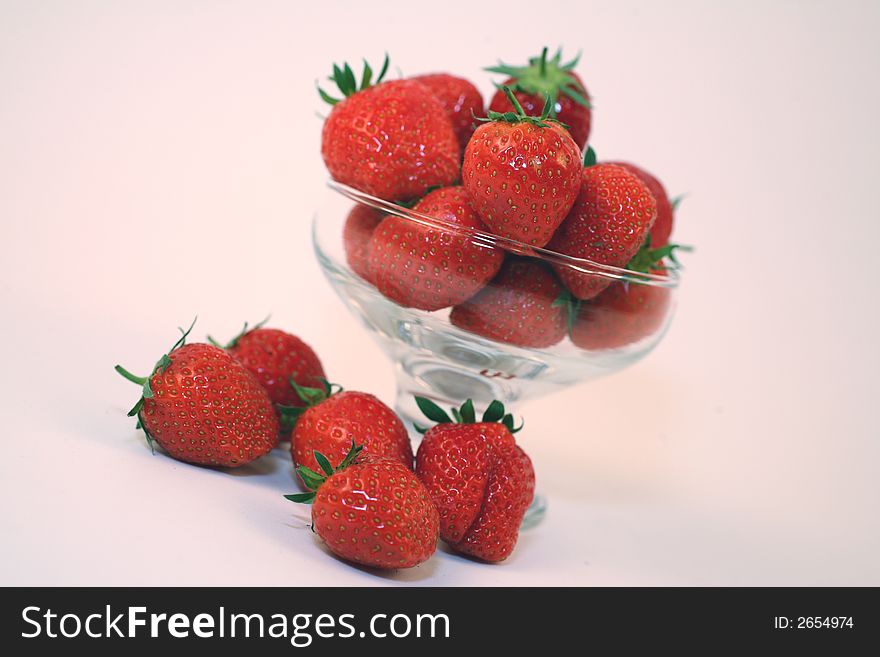 A small glass serving dish filed with fresh strawberries