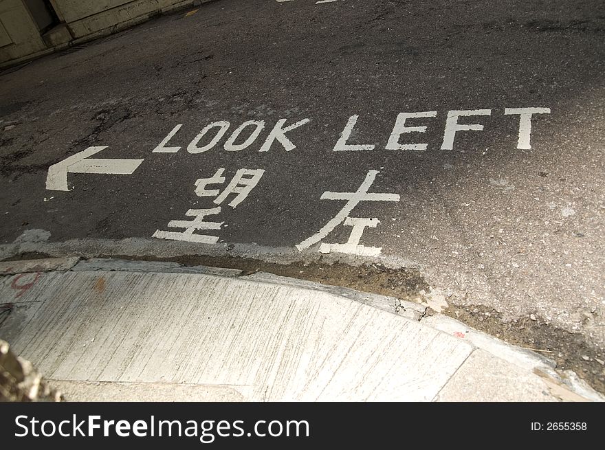 Road markings on a street in Hong Kong, showing look left and look right