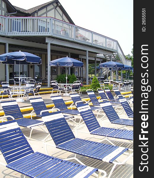 Outdoor swimming pool in the resort with long chair and sun umbrellas. Outdoor swimming pool in the resort with long chair and sun umbrellas