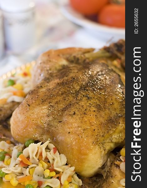 Roasted Chicken on a platter with mixed vegetables and pasta.