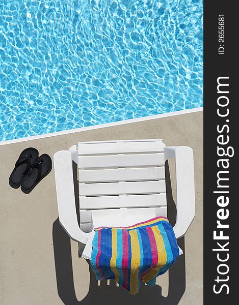 Chair, towel, and flipflops by the pool. Chair, towel, and flipflops by the pool