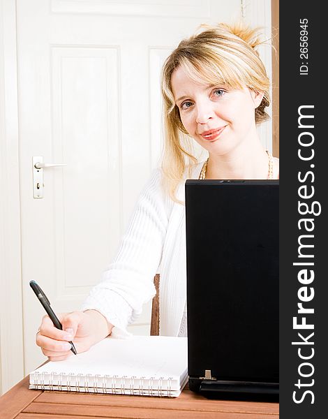 A blond business woman taking notes. A blond business woman taking notes