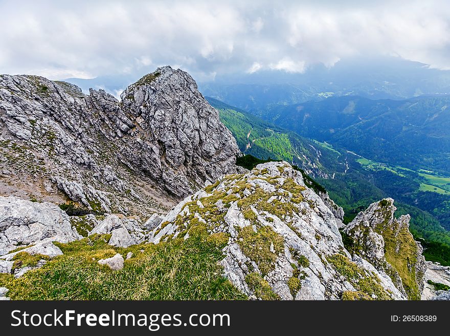 Rocks with cloudy sky behind on wide alley background,  Peca, Slovenia. Rocks with cloudy sky behind on wide alley background,  Peca, Slovenia