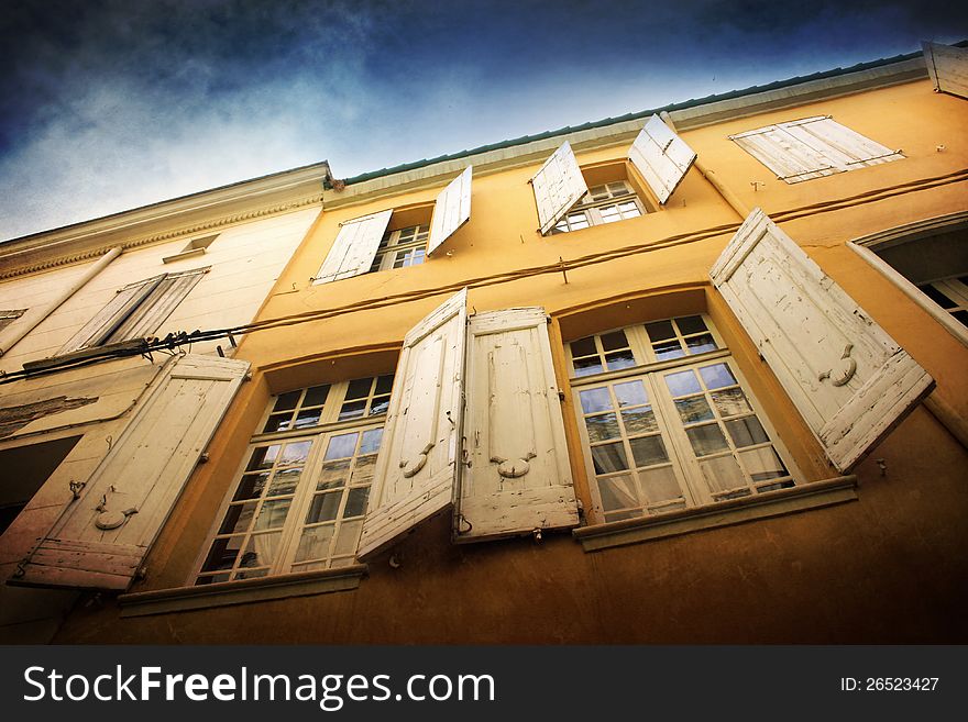 White windows of the yellow house with dark blue sky