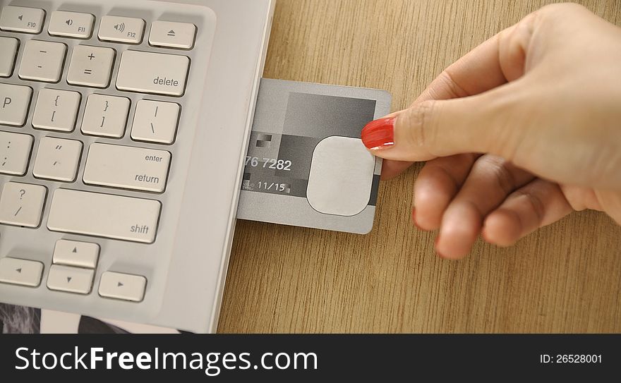 Credit card insert inside laptop on the wooden desk