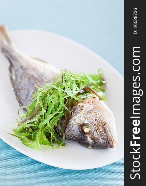 Grilled sea bream and seaweed salad, selective focus