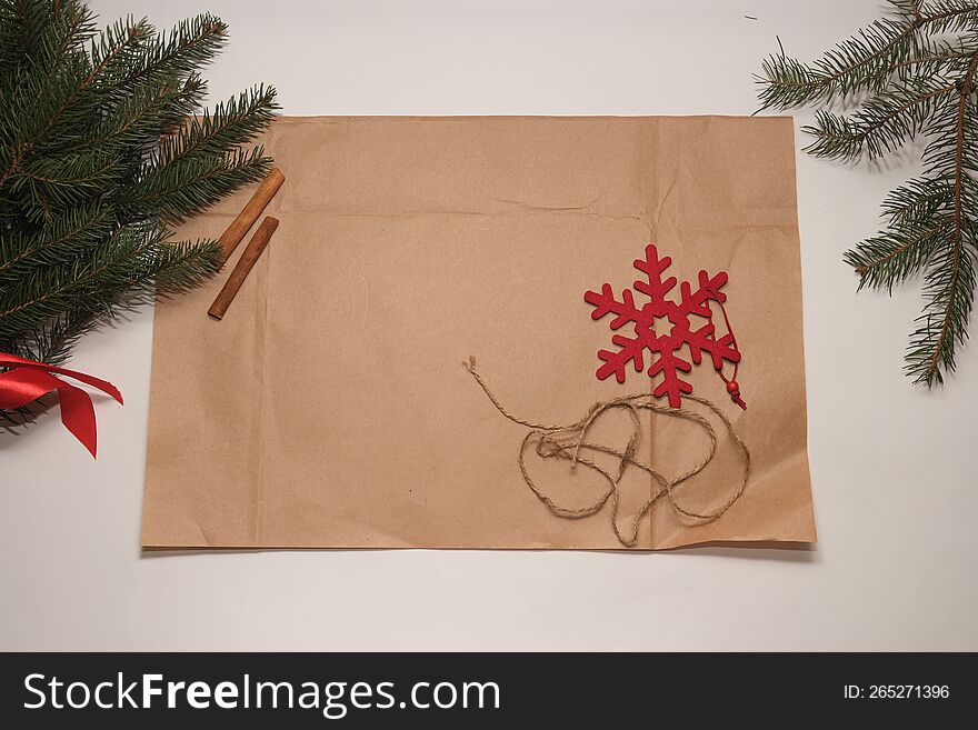 Brown paper on white background with fir branches and cinnamon