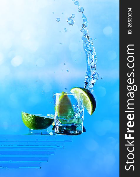 Lime and glass with tequila on a blue background