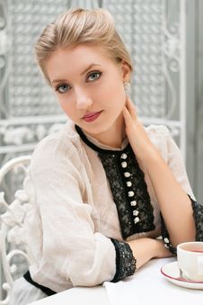 Young Beautiful Woman Sits At Table Royalty Free Stock Photography
