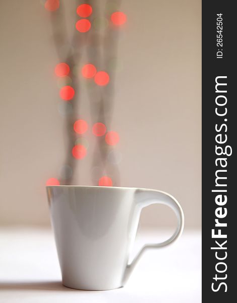 Cup of hot coffee on a background of lights