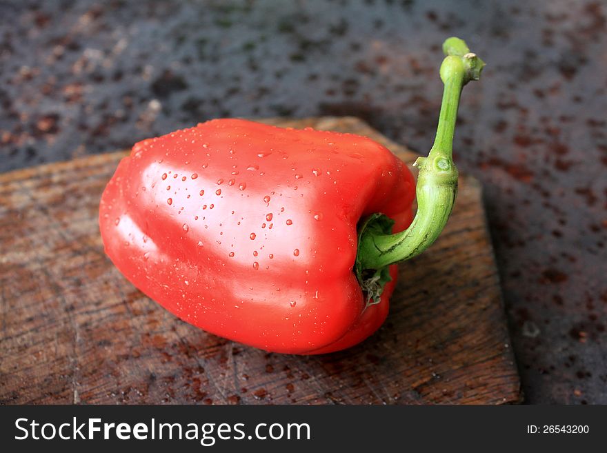 Red pepper on a wooden background close-up