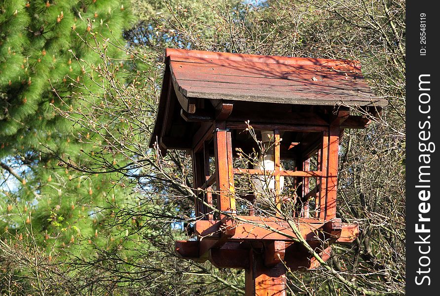 Beautiful wooden lamp in east style among trees in a city Japanese garden. Beautiful wooden lamp in east style among trees in a city Japanese garden