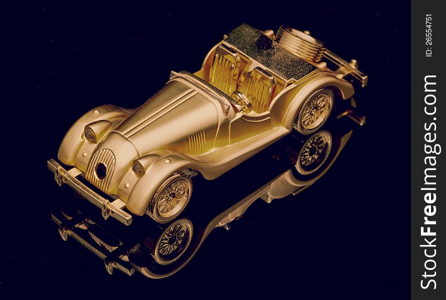 Gold little toy car on black. Gold little toy car on black