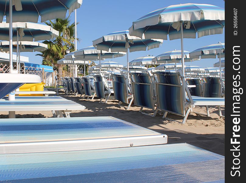 Detail of a row of chairs with umbrellas on the beach. Detail of a row of chairs with umbrellas on the beach.