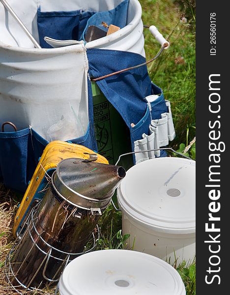 Beekeeping equipment awaits use including a beehive smoker and pails for collecting honey. Beekeeping equipment awaits use including a beehive smoker and pails for collecting honey.