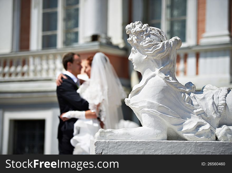 Bride And Groom Near Sculpture Of Female Lion