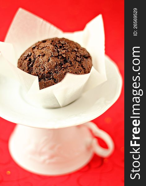 Vegan chocolate muffin on a white saucer