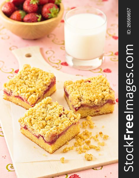 Strawberry crumb cake with a glass of milk and a bowl of fresh strawberries