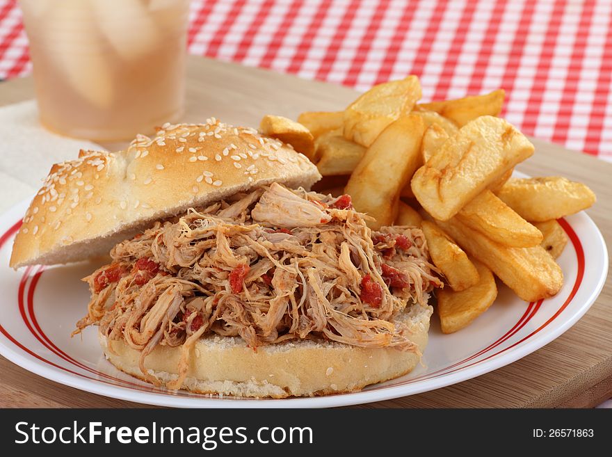 Pullled pork sandwich with french fries on a plate. Pullled pork sandwich with french fries on a plate