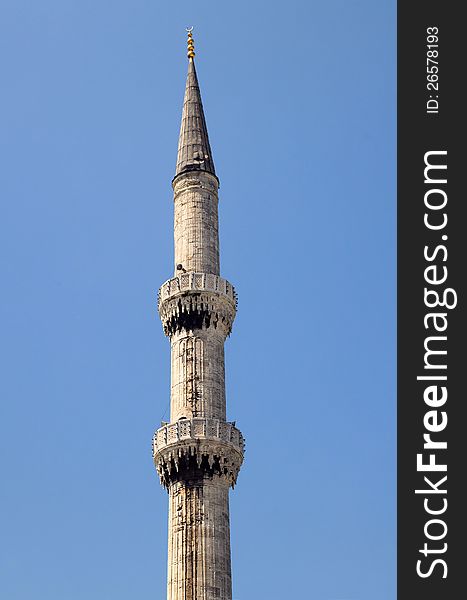 Fragment of one of the Blue Mosque minarets against blue sky background in Istanbul, Turkey