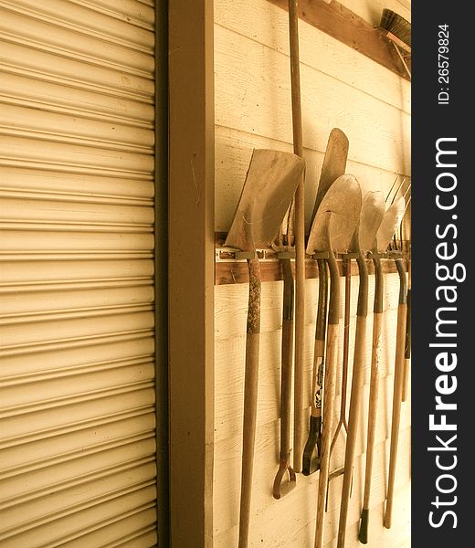 Old tools line the side of a shed waiting to be used again. Old tools line the side of a shed waiting to be used again.