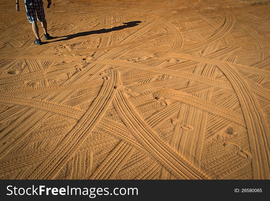 A series of traces of feet and tires in the desert. A series of traces of feet and tires in the desert