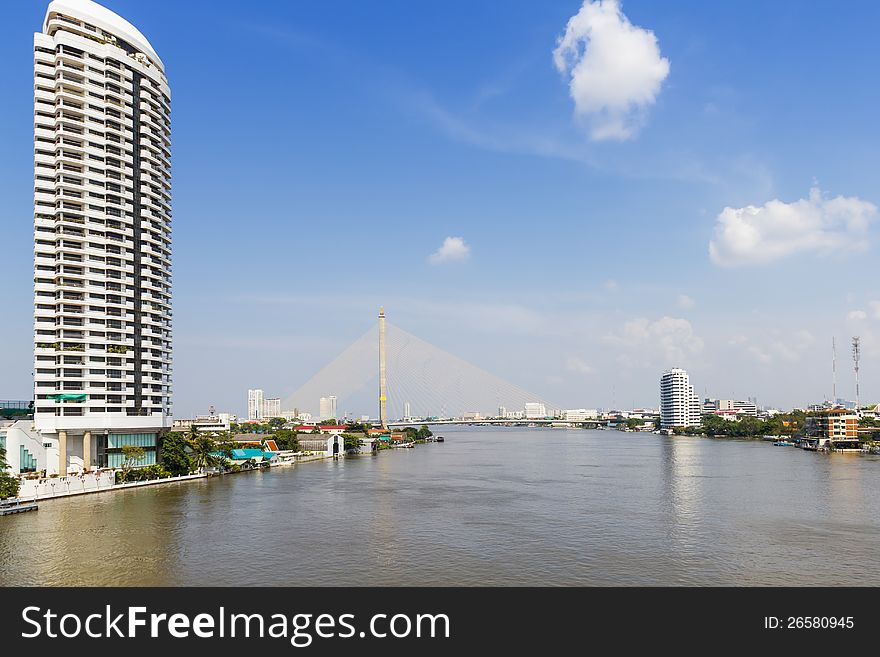 Chaopraya river waterfront in Bangkok with Rama VIII bridge in background, Thailand