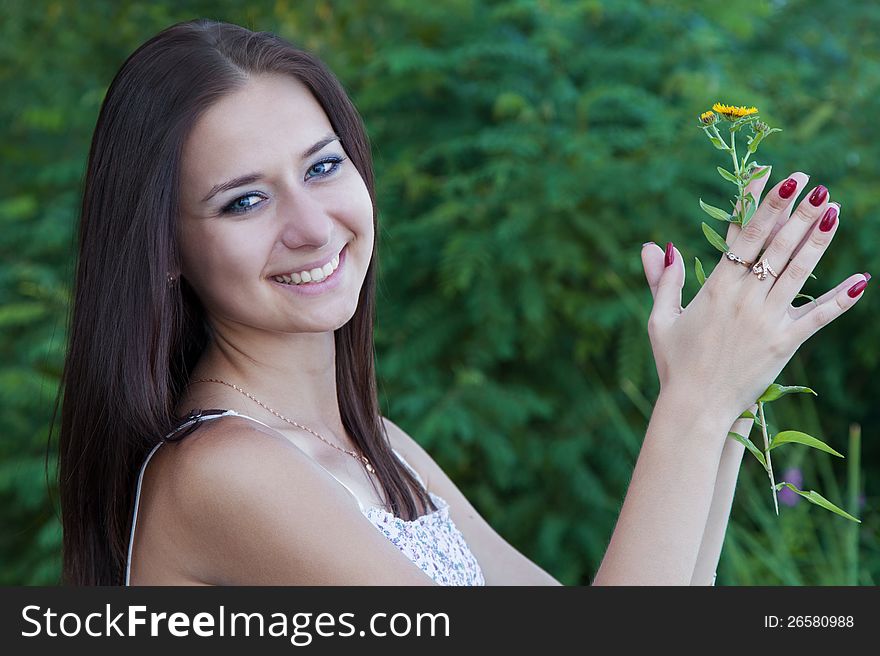 Portrait attractive young woman with flower outdoors