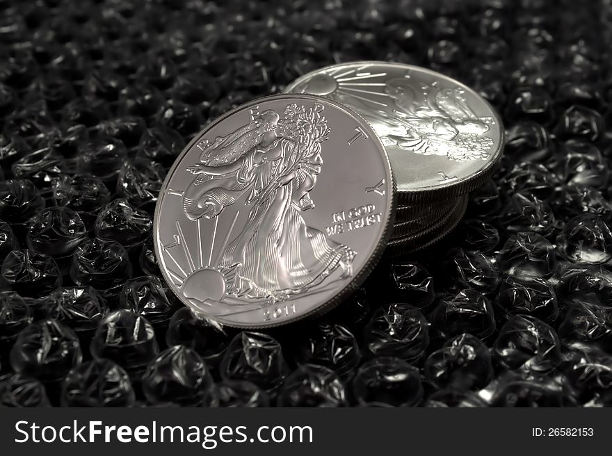 Silver Dollars on bubble wrap to represent protecting your investments