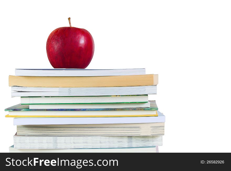 Book stack with fresh red apple on top in white background