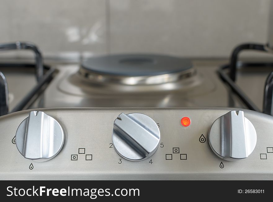 Electrical stove knob in kitchen work top with operation light on. Electrical stove knob in kitchen work top with operation light on