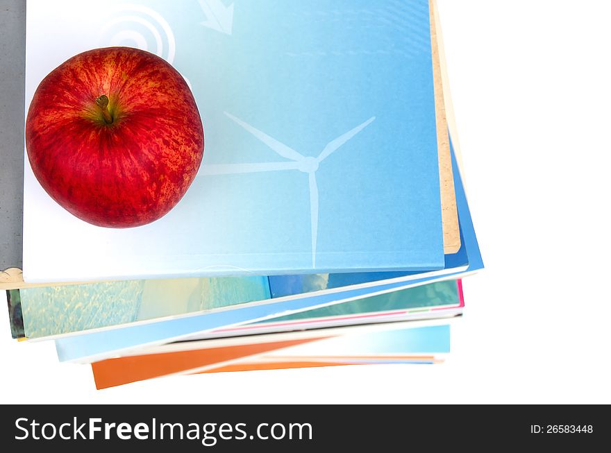 One red apple on top of book stack in white background