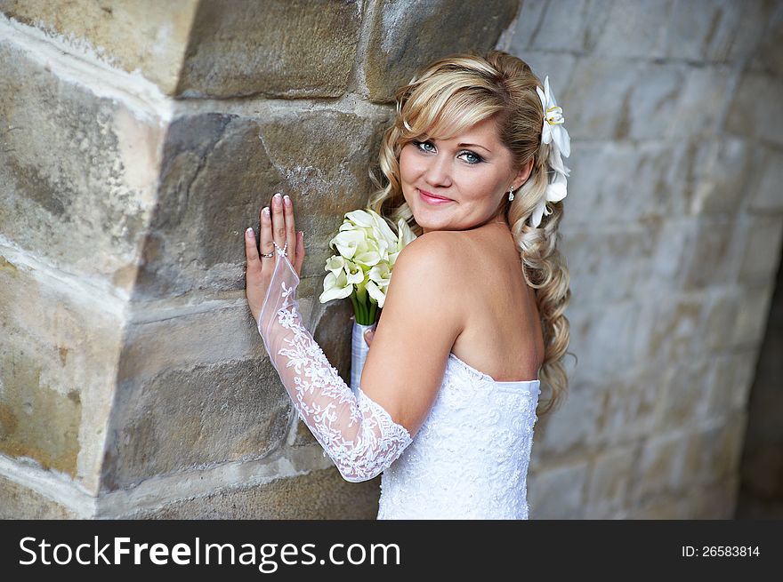 Happy bride near stone wall