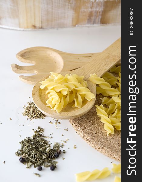 Close up raw pasta on spoon with spices. Close up raw pasta on spoon with spices