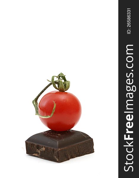 Fresh tomatoe on piece of dark chocolate presented on white. Fresh tomatoe on piece of dark chocolate presented on white