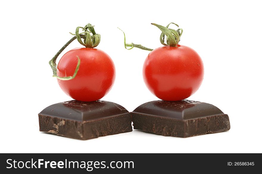 Fresh tomatoe on piece of dark chocolate presented on white. Fresh tomatoe on piece of dark chocolate presented on white