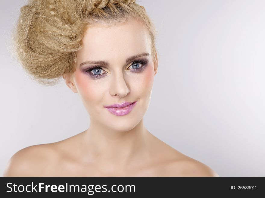 Young pretty woman with beautiful blond hairs and multicolor makeup isolated on white background