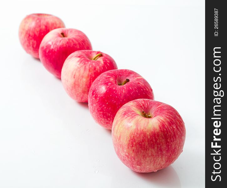 Line of red apples  on white