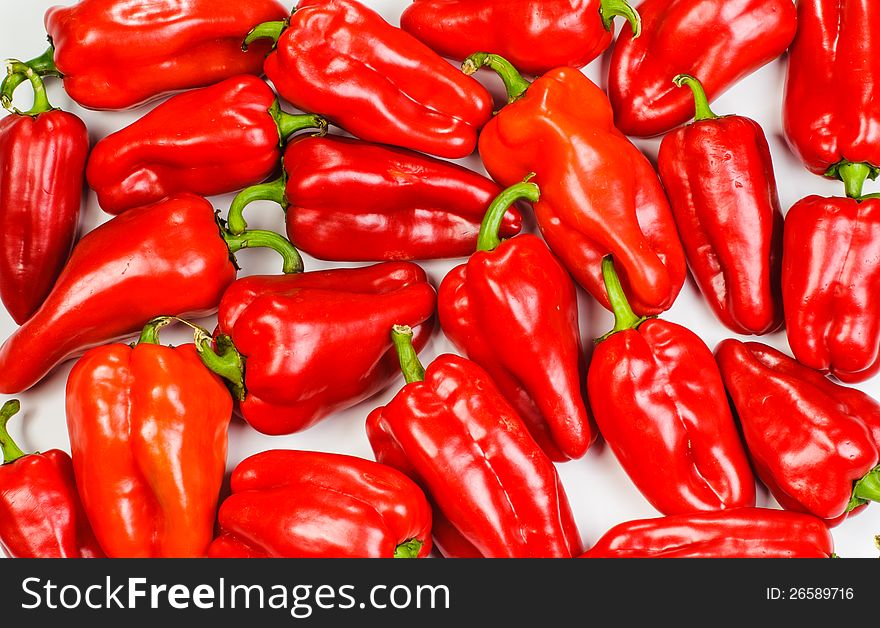 Many red sweet peppers lay on white background. Many red sweet peppers lay on white background