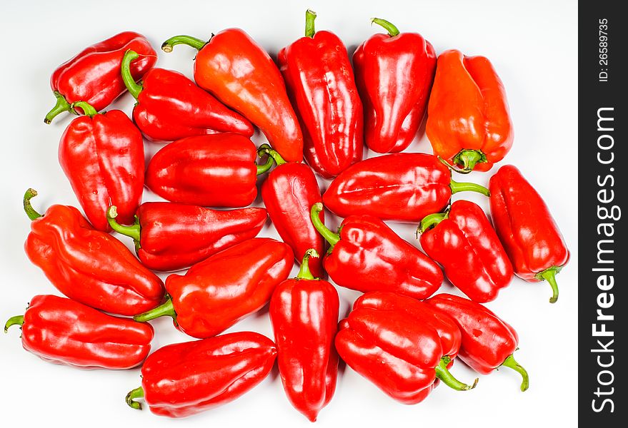 Many red sweet peppers lay on white background. Many red sweet peppers lay on white background