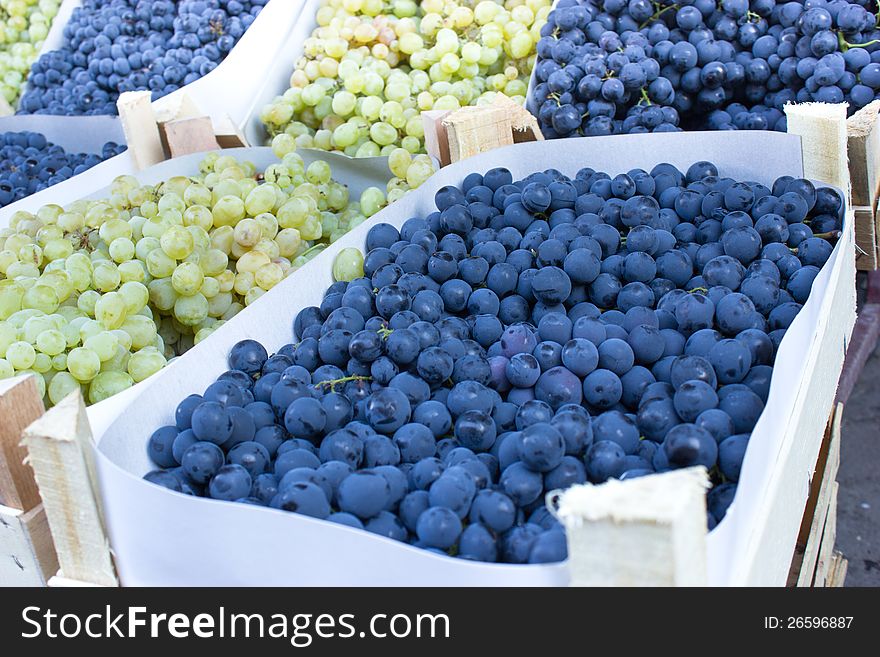 Organic grapes in crates on market stalls