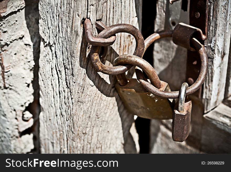 Rusty padlock attached to wooden door