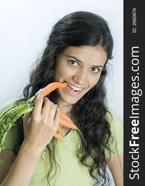 Girl holding carrots and eating. Girl holding carrots and eating