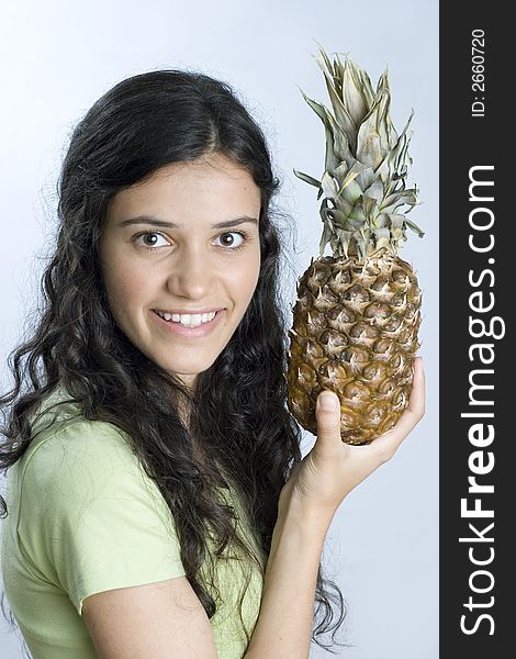 Smiling girl in green holding pineapple. Smiling girl in green holding pineapple