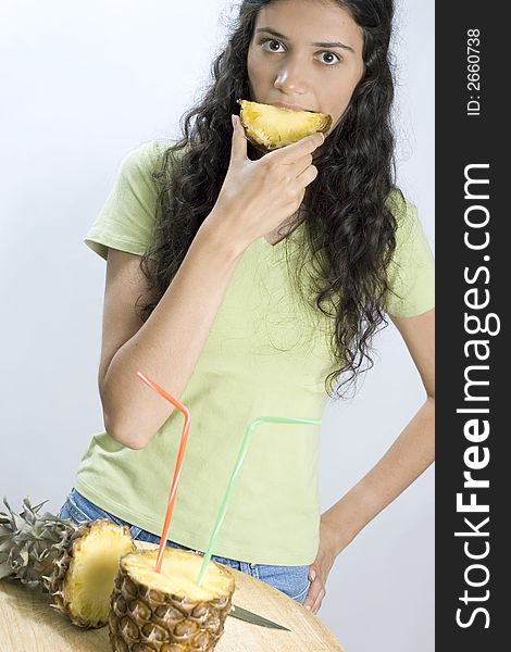 Smiling girl eating piece of pineapple. Smiling girl eating piece of pineapple