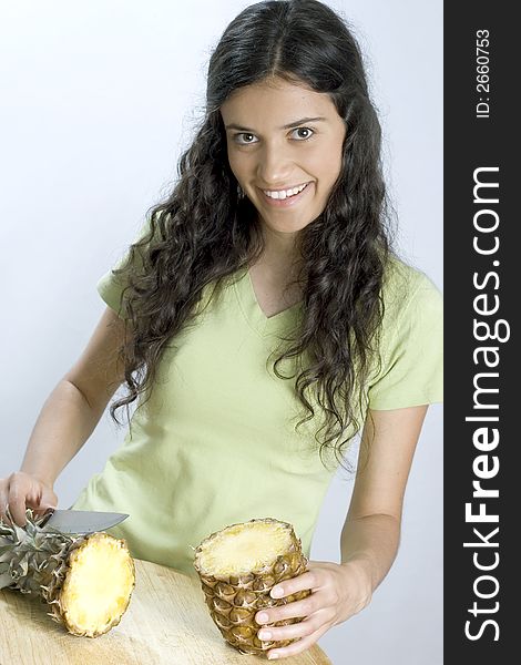 Smiling girl is cutting pineapple. Smiling girl is cutting pineapple