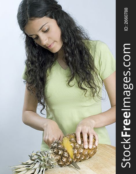 Smiling girl is cutting pineapple. Smiling girl is cutting pineapple